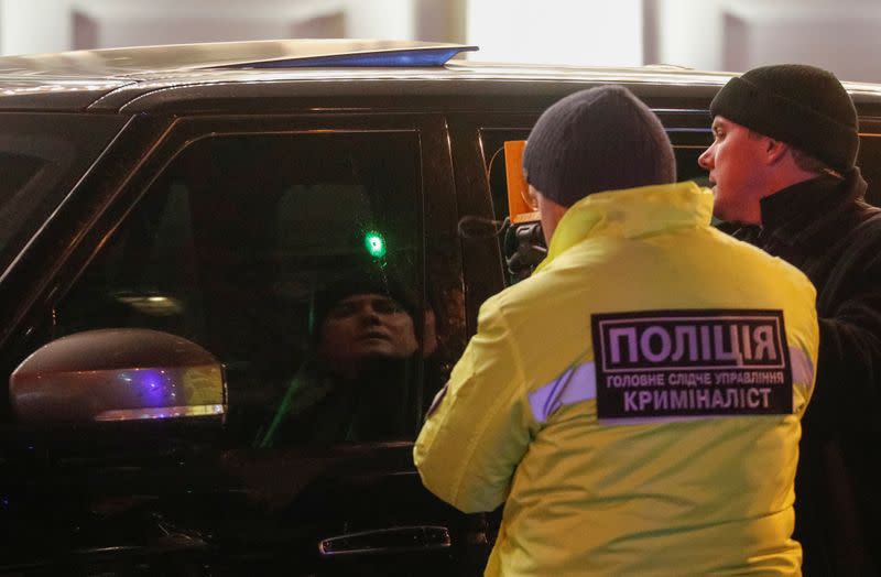 Investigators inspect a car at a site of a murder attempt on Viacheslav Soboliev in Kiev