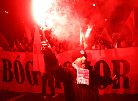 People carry Polish flags and burn flares during a march marking the 100th anniversary of Polish independence in Warsaw, Poland November 11, 2018. REUTERS/Kacper Pempel