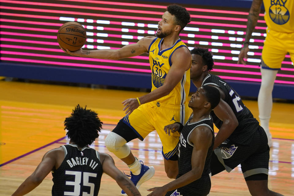 Golden State Warriors guard Stephen Curry, center, shoots against the Sacramento Kings during the first half of an NBA basketball game in San Francisco, Monday, Jan. 4, 2021. (AP Photo/Jeff Chiu)