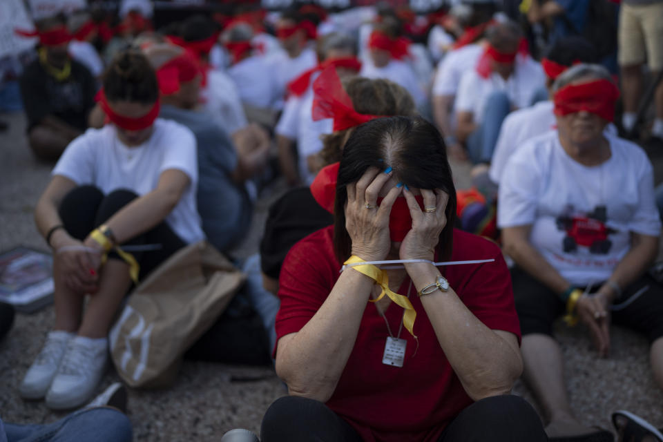 Residents of Kibbutz Kfar Azza bind their hands and wear blindfolds during a demonstration in solidarity with friends and relatives held hostage in the Gaza Strip, in Tel Aviv, Israel, Thursday, Nov. 2, 2023. The small farming community was overrun by Hamas militants during a bloody cross-border raid from Gaza on Oct. 7. Eighteen residents were kidnapped and taken to Gaza, among them seven children, the youngest 3 years old. (AP Photo/Oded Balilty)