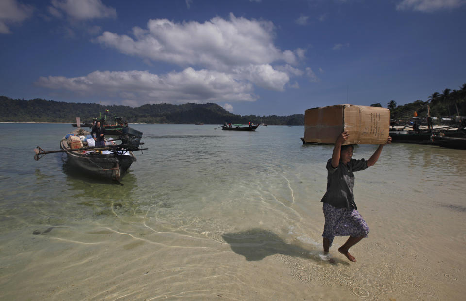 In this Feb. 11, 2014 photo, a Myanmarese fisherwoman carries a box containing supplies for Ma Kyone Galet village, inhabited by Moken and Myanmarese fishermen, on Bocho Island in Mergui Archipelago, Myanmar. The Moken, the sea nomads who have inhabited the Mergui archipelago for centuries, would make ideal nature guides.(AP Photo/Altaf Qadri)