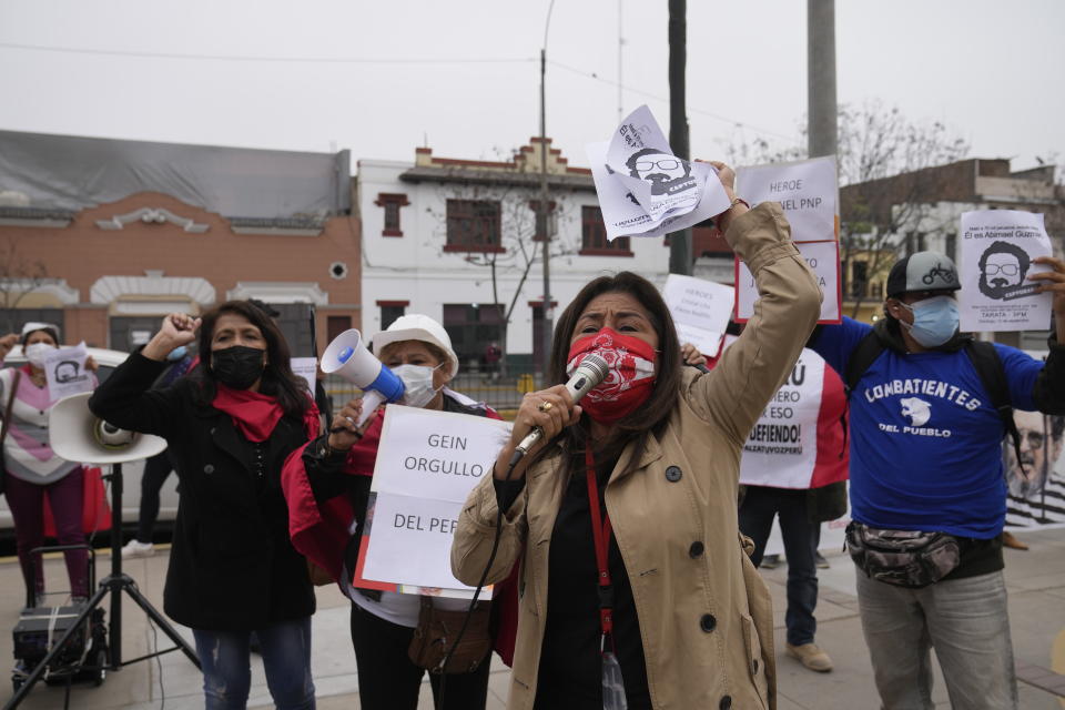 People gather outside the anti-terrorism directorate to celebrate the death of Abimael Guzman, founder and leader of the Shining Path guerrilla movement, in Lima, Peru, Saturday, Sept. 11, 2021. Guzman who was captured in 1992, died on Saturday in a military hospital after an illness, the Peruvian government said. He was 86. (AP Photo/Martin Mejia)