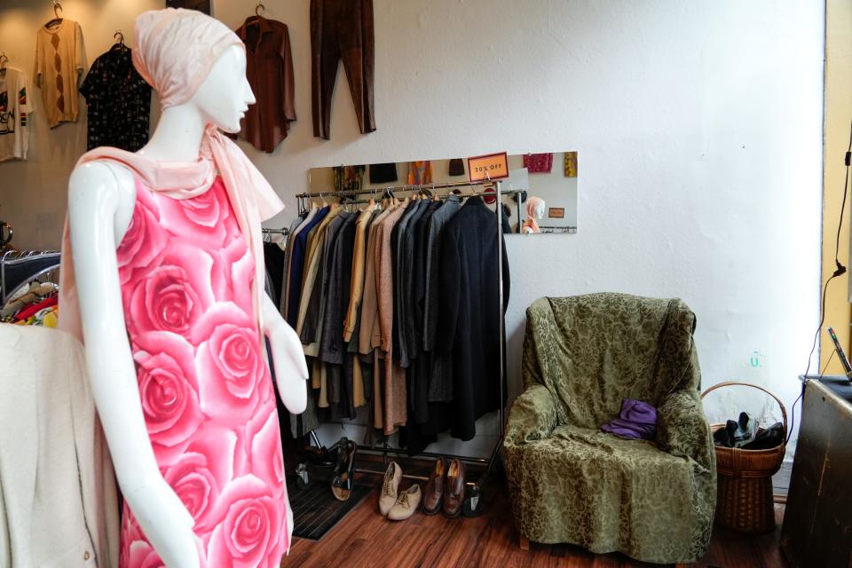 A mannequin draped in rose pink vintage clothing pieces greets customers at the front door.