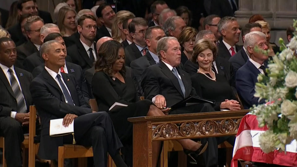 Former President George W. Bush slips a piece of candy to former First Lady Michelle Obama during Sen. John McCain's funeral on Saturday, Sept. 1, 2018