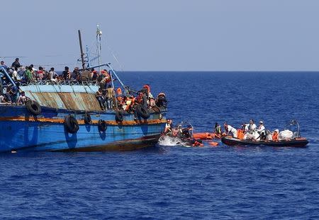 Migrants in the water scramble to get onto Migrant Offshore Aid Station (MOAS) rescue boats launched from the MOAS ship Phoenix after they jumped from an overloaded wooden boat during a rescue operation 10.5 miles (16 kilometres) off the coast of Libya August 6, 2015. REUTERS/Darrin Zammit Lupi MALTA OUT