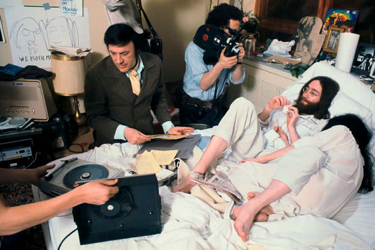 John Lennon y Yoko Ono en 1969 en la cama del Hotel Queen Elizabeth en Montreal mientras el legendario DJ de Nueva York "Murray the K" transmite en vivo ry un camarografo los filma