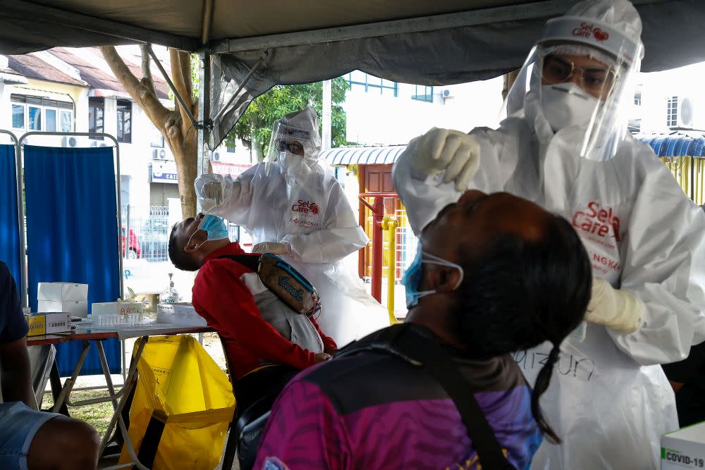 Healthcare workers collect swab samples to test for Covid-19 during a mass screening exercise in Taman Manggis, George Town August 12, 2021. — Picture by Sayuti Zainudin