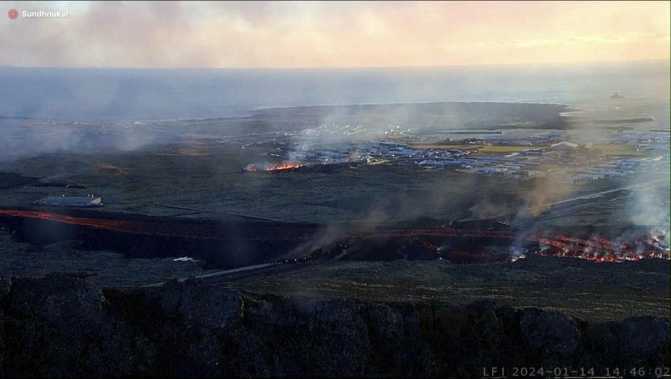 This photo provided by LIVEFROMICELAND.IS shows lava on the move toward the community from an erupting volcano in Iceland near the town of Grindavik, Iceland, Sunday Jan. 14, 2024. A volcano erupted in southwestern Iceland Sunday for the second time in less than a month, sending semi-molten rock toward a nearby settlement. The eruption just before 8 a.m. came after a swarm of earthquakes near the town of Grindavik, the Icelandic Meteorological Office said. The community was evacuated overnight. (LIVEFROMICELAND.IS via AP)