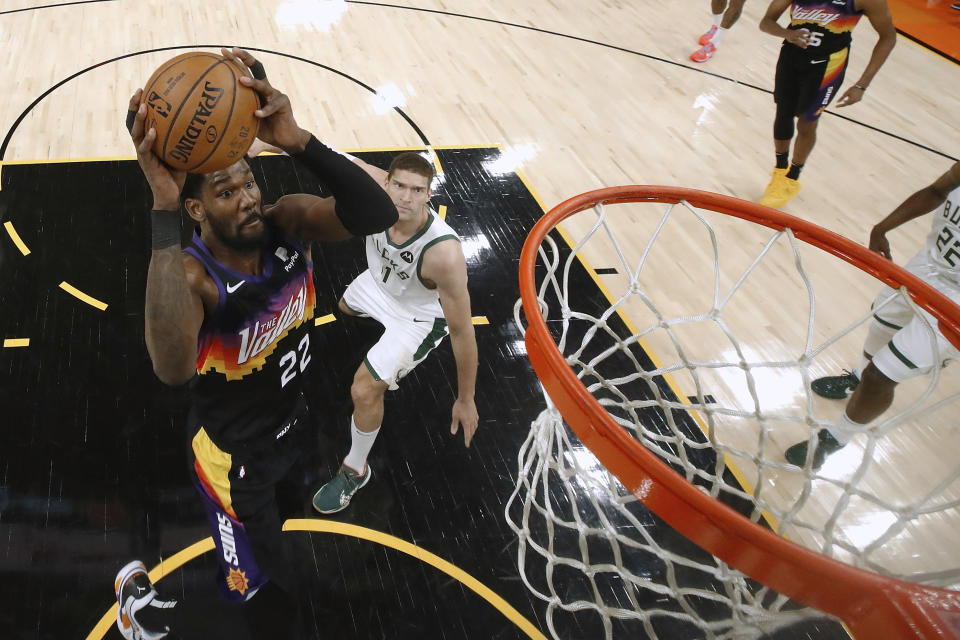 Phoenix Suns' Deandre Ayton (22) attempts a shot ahead of Milwaukee Bucks' Brook Lopez (11) during the first half of Game 1 of basketball's NBA Finals, Tuesday, July 6, 2021, in Phoenix. (Christian Petersen/Pool Photo via AP)