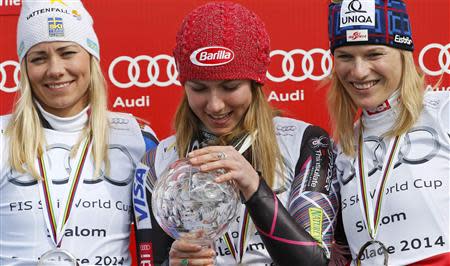 Mikaela Shiffrin of the U.S. is flanked by second placed Frida Hansdotter of Sweden (L) and third placed Marlies Schild of Austria after winning the women's overall slalom trophy during a ceremony at the FIS Alpine Skiing World Cup Finals in Lenzerheide March 15, 2014. REUTERS/Leonhard Foeger
