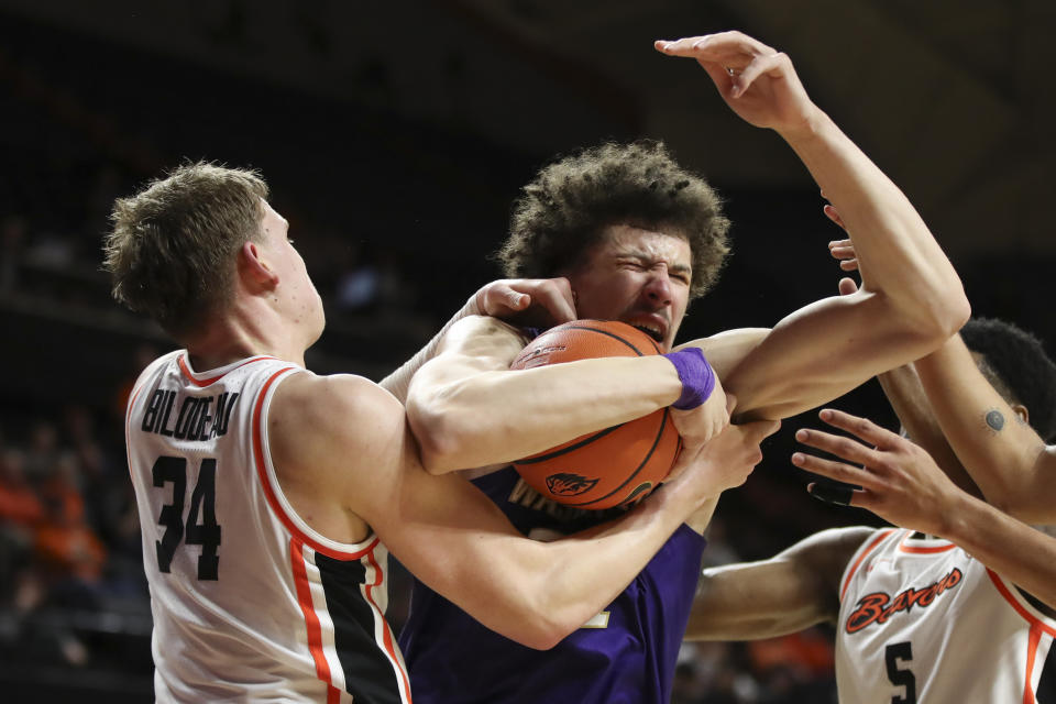 Oregon State forward Tyler Bilodeau, left, and Washington center Braxton Meah (34), right, grab for a rebound during the second half of an NCAA college basketball game Saturday, Feb. 10, 2024, in Corvallis, Ore. Washington won 67-55. (AP Photo/Amanda Loman)