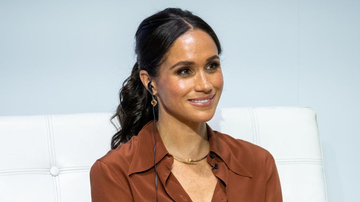 A photo of Meghan Markle sitting on stage