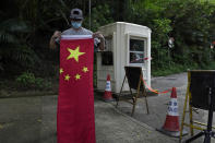 A pro-China supporter folds a Chinese national flag after a protest against the U.S. sanctions outside the U.S. Consulate in Hong Kong Saturday, Aug. 8, 2020. The U.S. on Friday imposed sanctions on Hong Kong officials, including the pro-China leader of the government, accusing them of cooperating with Beijing's effort to undermine autonomy and crack down on freedom in the former British colony. (AP Photo/Vincent Yu)