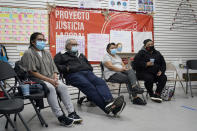 A group of immigrants watch President Joe Biden's inauguration from the Workers Justice Center, Wednesday, Jan. 20, 2021, in the Sunset Park neighborhood of Brooklyn in New York. From left are Josefina Tapia, who is unemployed but used to be a housekeeper, Vicente Salvador, 74, Graciela Uraga, a cleaning lady, and Blanca Cedillos, who admitted she was "nervous" and disappointed when Biden didn't mention immigration reform in his speech. (AP Photo/Kathy Willens)