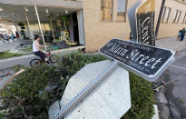 <p>A local resident rides his bike past a toppled street sign on Main Street, Thursday, July 19, 2018, in Marshalltown, Iowa. Several buildings were damaged by a tornado in the main business district in town including the historic courthouse. (Photo: Charlie Neibergall/AP) </p>