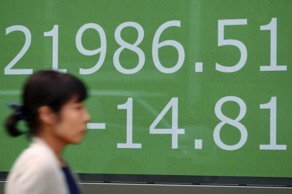 A woman walks past an electronic stock board showing Japan's Nikkei 225 index at a securities firm in Tokyo Wednesday, Sept. 18, 2019. Asian stock prices rose Wednesday after oil prices fell back and Wall Street advanced. (AP Photo/Eugene Hoshiko)