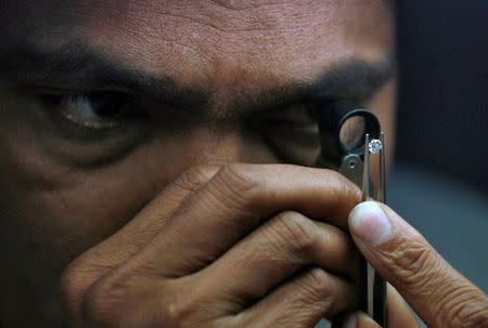 FILE PHOTO: A supervisor checks the shape of a polished diamond inside the diamond processing unit at Surat, in the western Indian state of Gujarat January 5, 2013. REUTERS/Amit Dave/File Photo