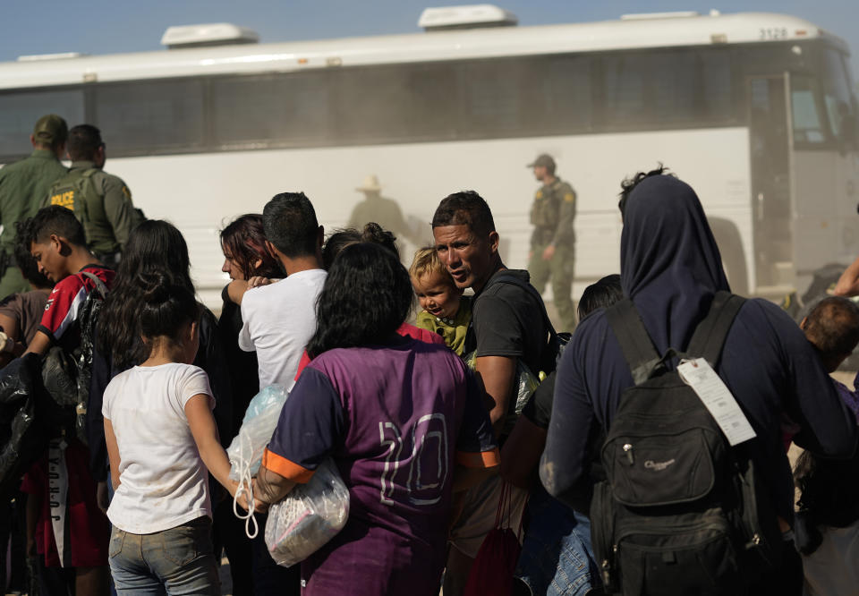 Migrants wait to board busses as they are processed by the U.S. Customs and Border Patrol after they crossed the Rio Grande and entered the U.S. from Mexico, Thursday, Oct. 19, 2023, in Eagle Pass, Texas. Starting in March, Texas will give police even broader power to arrest migrants while also allowing local judges to order them out of the U.S. under a new law signed by Republican Gov. Greg Abbott. (AP Photo/Eric Gay)