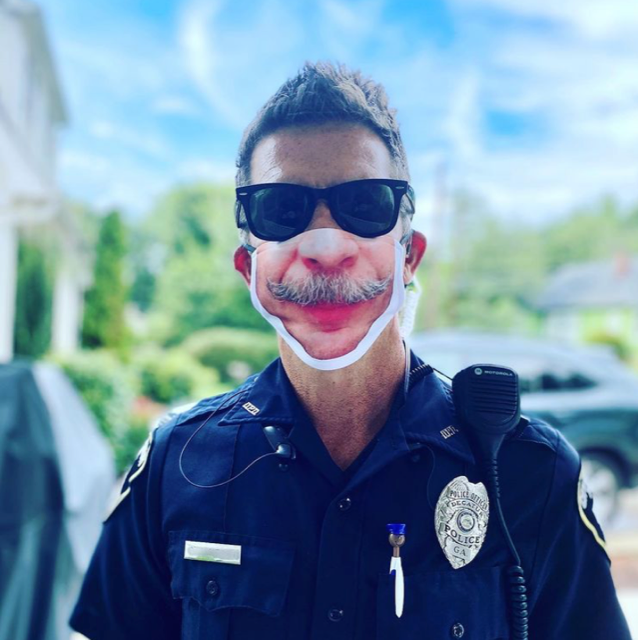 Joe Jameson, a police officer in Georgia, is able to wear his mustache on his mask after he had to shave it off because it could not fit under the facial covering.  / Credit: Handout / Huckleberry Starnes