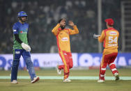 Islamabad United pacer Amad Butt, center, celebrates with teammate after taking the wicket of Multan Sultans batsman James Vince, left, during their Pakistan Super League T20 cricket match at Gaddafi stadium in Lahore, Pakistan, Saturday, Feb. 22, 2020. (AP Photo/K.M. Chaudary)