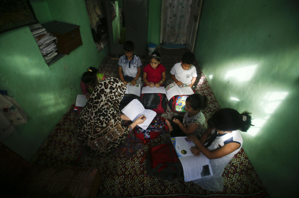 Kashmiri children attend private classes at a teacher's residence in Srinagar, Indian controlled Kashmir, Wednesday, Aug. 28, 2019. India's government, led by the Hindu nationalist Bharatiya Janata Party, imposed a security lockdown and communications blackout in Muslim-majority Kashmir to avoid a violent reaction to the Aug. 5 decision to downgrade the region's autonomy. The restrictions have been eased slowly, with some businesses reopening, some landline phone service restored and some grade schools holding classes again, though student and teacher attendance has been sparse. (AP Photo/Mukhtar Khan)