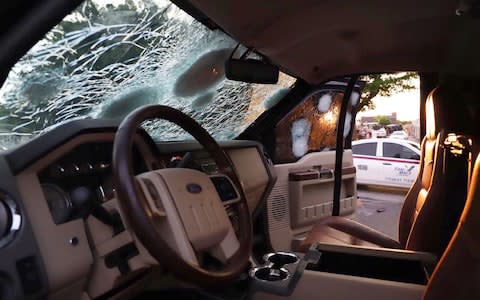 A bullet-ridden vehicle remains on the street of Culiacan, in the Mexican state of Sinaloa, following a shootout between armed gunmen and Mexican security forces.  - Credit: Rashide Frias/Getty