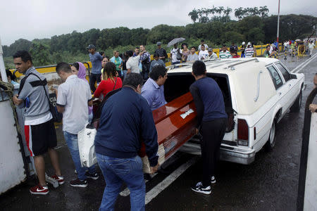 Men put a coffin in a hearse after crossing from Colombia into Venezuela at the Simon Bolivar international bridge in San Antonio del Tachira, Venezuela February 13, 2018. REUTERS/Carlos Eduardo Ramirez