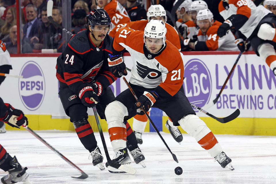 Philadelphia Flyers' Scott Laughton (21) controls the puck in front of Carolina Hurricanes' Seth Jarvis (24) during the first period of an NHL hockey game in Raleigh, N.C., Wednesday, Nov. 15, 2023. (AP Photo/Karl B DeBlaker)