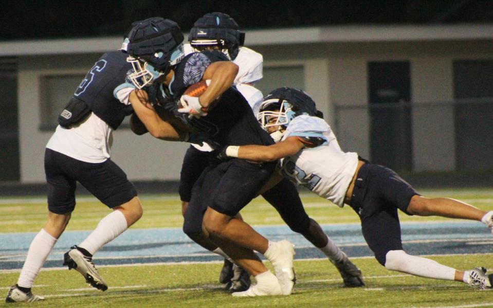 A running back drags a defensive player Bartlesville High Columbia vs. White spring game on May 25, 2023, at Custer Stadium.