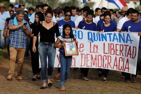 Luz Quintana (tercera desde la izquierda) lleva una foto de su padre Rodrigo, quien murió por un balín de goma disparado por la policía a la sede del Partido Liberal, tras una jornada de disturbios. La Colmena, Paraguay. 2 de abril de 2017. Un proyecto para habilitar la reelección presidencial en Paraguay, que desató disturbios en la capital el fin de semana, quedó en suspenso en el Congreso mientras la clase política busca una salida a la crisis originada cuando la iniciativa fue aprobada por un grupo de senadores. REUTERS/Jorge Adorno