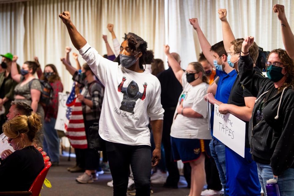 Protesters hold their fists up as they interrupt the Knox County Commission meeting at the City County Building in downtown Knoxville on April 19, 2021.