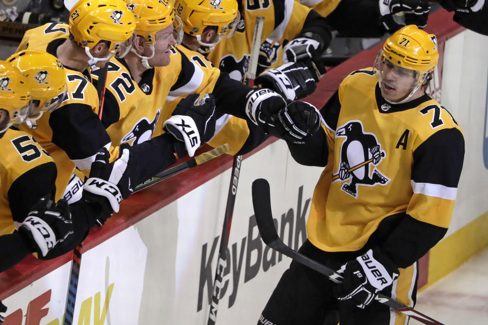 Pittsburgh Penguins' Evgeni Malkin (71) celebrates with teammates after assisting on a goal by Phil Kessel, for the 1,000th point of his NHL career during the third period of an NHL hockey game against the Washington Capitals in Pittsburgh, Tuesday, March 12, 2019. The Penguins won 5-3. (AP Photo/Gene J. Puskar)