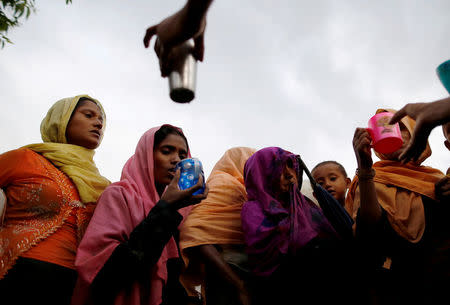 Local Bangladeshi people offer water as Rohingya refugees arrive in Teknaf, Bangladesh, September 1, 2017. REUTERS/Mohammad Ponir Hossain