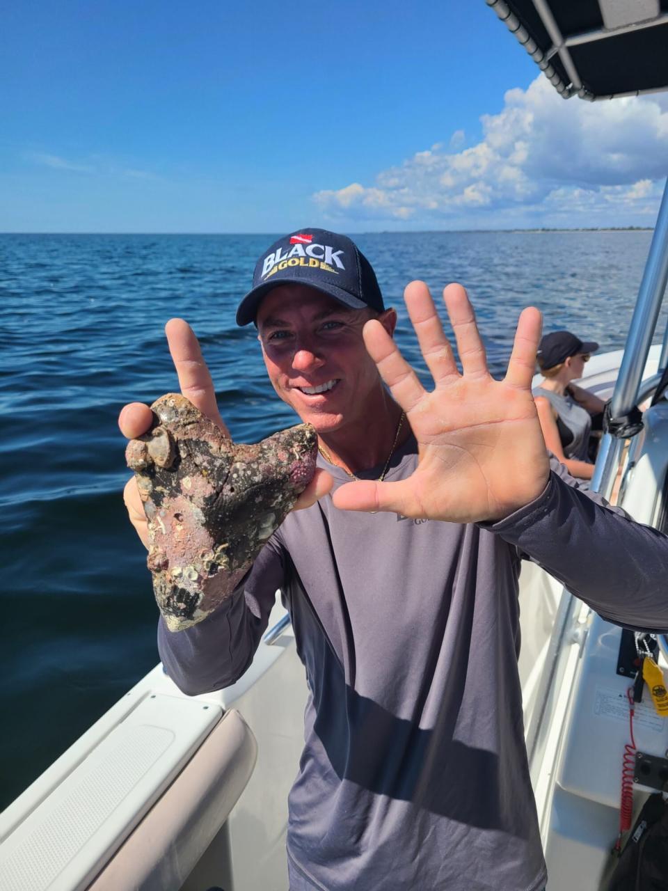 Man holds giant shark tooth