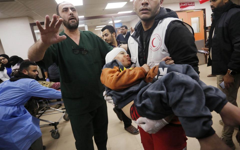 Injured Palestinians, including children, are brought to Al-Aqsa Martyrs Hospital for medical treatment following Israeli attacks in Deir al Balah, Gaza