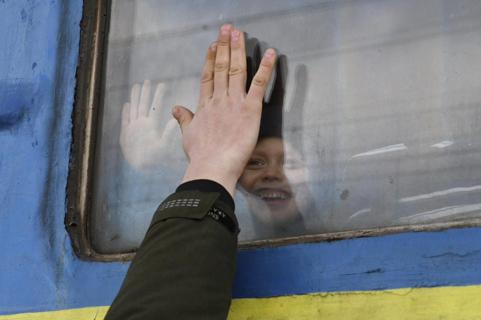 FILE - A child says goodbye to a relative looking out the window of a train carriage waiting to leave Ukraine for western Ukraine at the railway station in Kramatorsk, eastern Ukraine, on Feb. 27, 2022. The U.N. refugee agency says more than 4 million refugees have now fled Ukraine following Russia’s invasion, a new milestone in the largest refugee crisis in Europe since World War II. (AP Photo/Andriy Andriyenko)