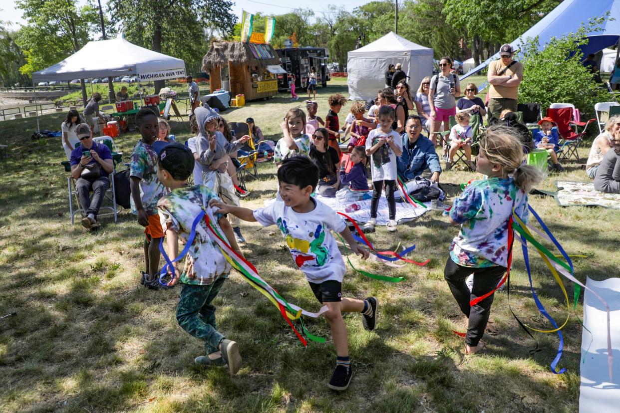 Lyle Lee, 7, of Troy, left, Ivan Yoo, 5, of Bloomfield Hills, and Elsie Mack, 6, of Detroit, run around and play before the Artlab J student performances begin at the Palmer Park art fair in Detroit on June 4, 2023.
