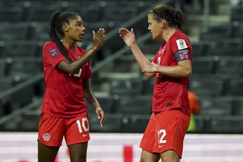 Canada's Christine Sinclair, right, is congratulated by teammate Ashley Lawrence.