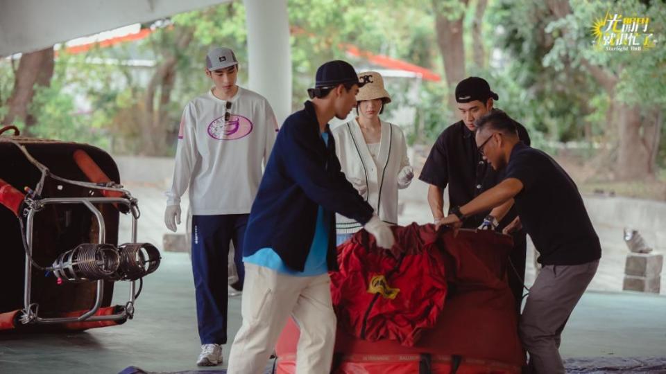 章廣辰（左起）、陳昊森、郭雪芙和周興哲搬運熱氣球器材。（圖／TVBS）