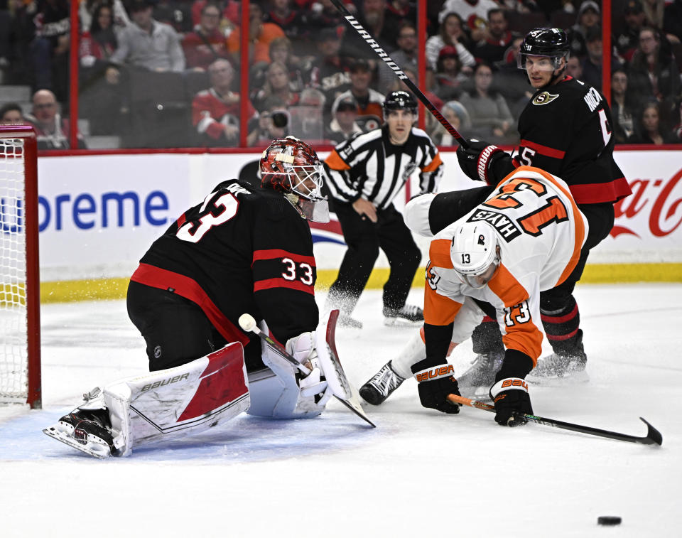 Ottawa Senators goaltender Cam Talbot (33) watches the rebound as defenseman Nick Holden (5) forces Philadelphia Flyers center Kevin Hayes (13) out of position during the first period of an NHL hockey game, Saturday, Nov. 5, 2022 in Ottawa, Ontario. (Justin Tang/The Canadian Press via AP)