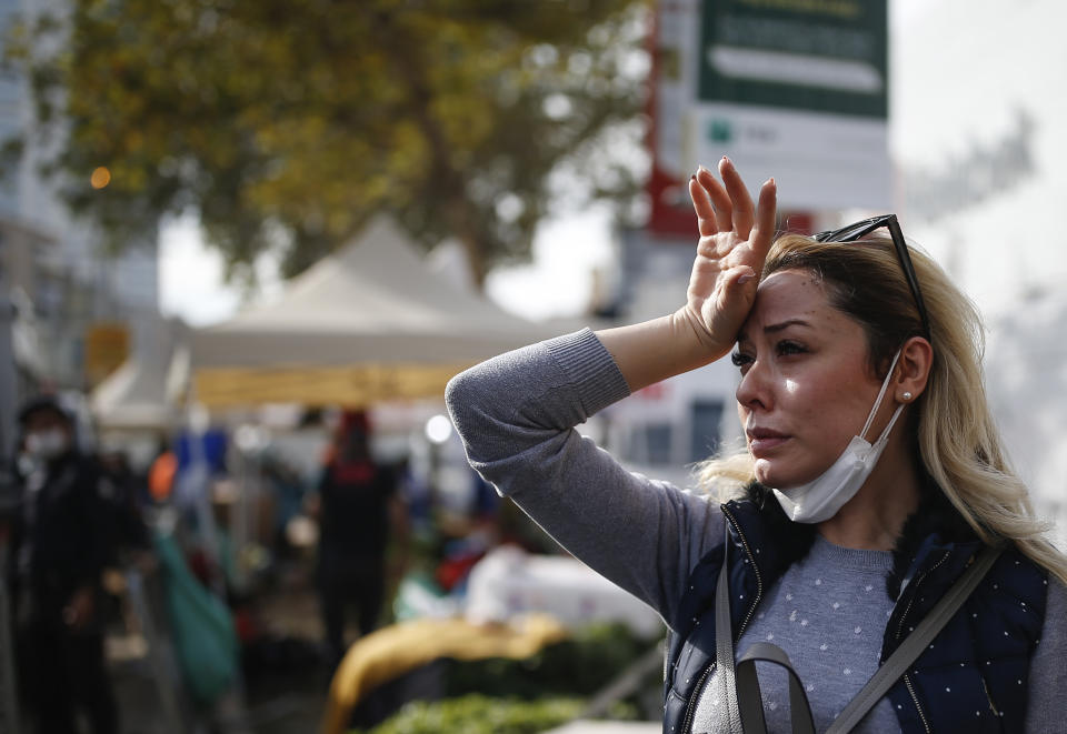 A woman pauses at a basketball court where tents had been set up to accommodate people after becoming homeless due to the Oct. 30 earthquake in Izmir, Turkey, Tuesday, Nov. 3, 2020. Rescuers in the Turkish coastal city pulled a young girl out alive from the rubble of a collapsed apartment building Tuesday, four days after a strong earthquake hit Turkey and Greece. (AP Photo/Emrah Gurel)