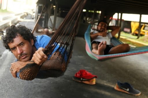 Truck drivers rest under a truck while waiting for protesters to clear a roadblock in Diriamba, 40 kilometers (25 miles) from Managua