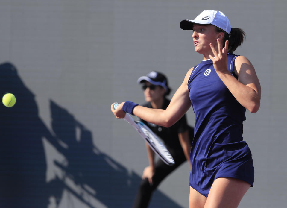 Iga Swiatek, of Poland, returns a shot to Maria Sakkari of Greece during the Mexican Tennis WTA Finals in Guadalajara, Mexico, Thursday, Nov. 11, 2021. (AP Photo/Refugio Ruiz)