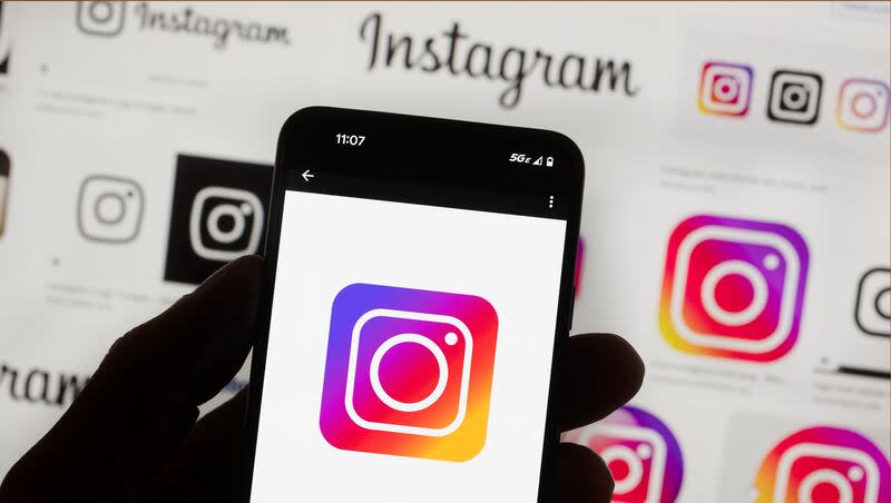 The Instagram logo is seen on a cell phone in Boston, Oct. 14, 2022. Instagram says it’s testing out new tools to protect young people and combat sexual extortion, including a feature that will automatically blur nudity in direct messages.