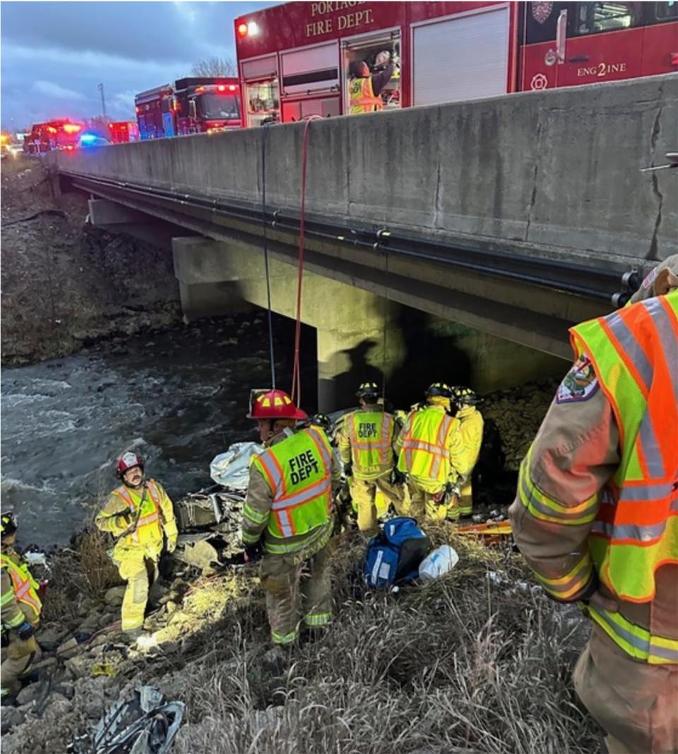 Police rescue a man from his damaged vehicle Tuesday, Dec. 26, 2023 along Interstate 94 near Portage, Ind. Authorities say the man drank rainwater to survive the ordeal while pinned in the wreckage beneath the Indiana highway bridge.