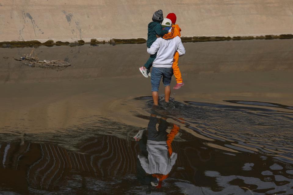 A migrant helps two Venezuelan children to cross the Rio Grande river from Ciudad Juarez, Chihuahua state, Mexico, to El Paso, Texas, US, in search of political asylum on Dec. 27, 2022. - The US government's two-year-old policy of invoking Covid-19 precautions to turn away hundreds of thousands of migrants at the Mexican border will remain in place, for now, the Supreme Court ruled Tuesday. The decision to uphold the controversial rule known as Title 42 stemmed from a looming political crisis for President Joe Biden, as thousands waited at the southern border in expectation the policy was about to end.