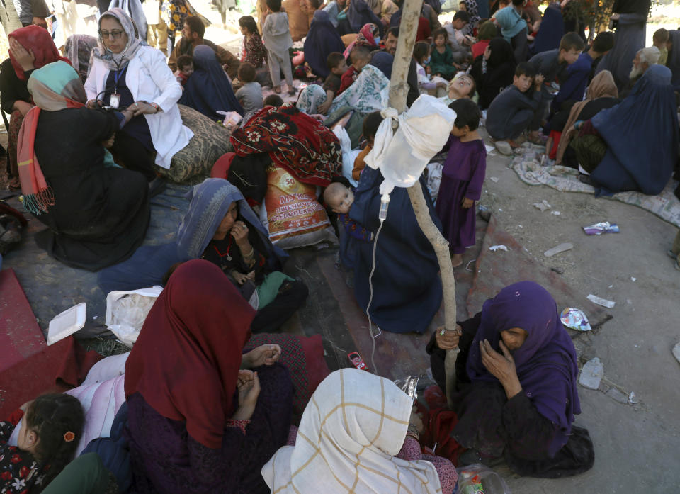 Internally displaced Afghan women from northern provinces, who fled their home due to fighting between the Taliban and Afghan security personnel, receive medical care in a public park in Kabul, Afghanistan, Tuesday, Aug. 10, 2021. (AP Photo/Rahmat Gul)