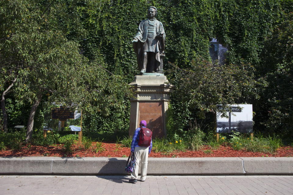 A passer-by looks up at a statue of Egerton Ryerson outside Toronto’s Ryerson University on Thursday July 6, 2017. The downtown University is named for Egerton Ryerson, a pioneer of public education in Ontario. There is a push to change the University’s name out of respect for residential school survivors. (Photo by Chris Young, The Canadian Press)