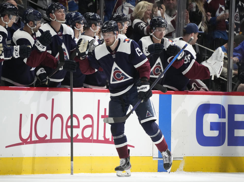 Colorado Avalanche right wing Valeri Nichushkin, front, is congratulated as he passes the team box after scoring a goal against the St. Louis Blues in the second period of an NHL hockey game Tuesday, April 26, 2022, in Denver. (AP Photo/David Zalubowski)