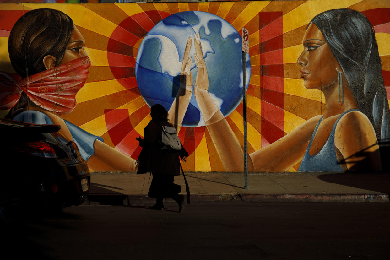 A pedestrian walks past the mural “¡Resiste!” by Nanibah Chacon outside Self-Help Graphics & Art, Inc. in Boyle Heights, Los Angeles. (Photo: Patrick T. Fallon for Yahoo News)